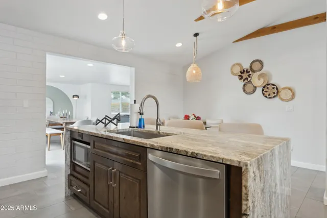 a kitchen with a sink a stove and a wooden floor