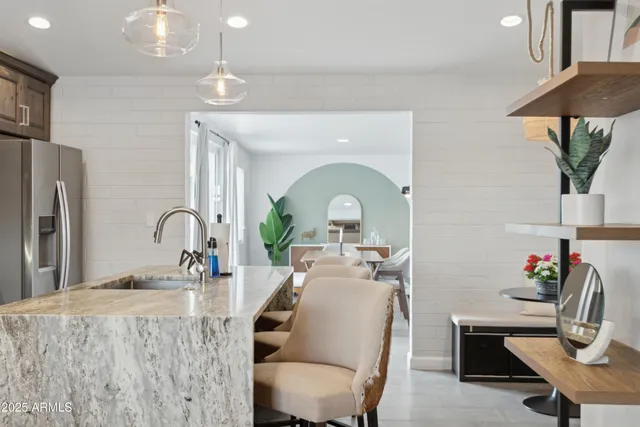 a kitchen with stainless steel appliances a table and chairs in it