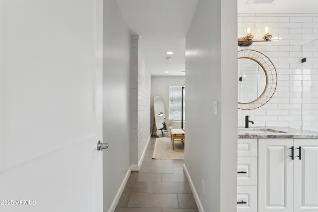 a en suite bathroom with a granite countertop sink and a mirror