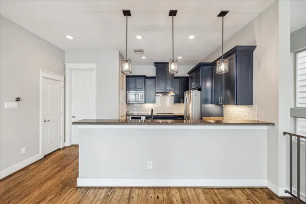 a kitchen with stainless steel appliances granite countertop a refrigerator and a stove top oven