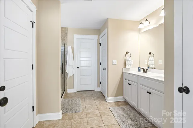 a en suite bathroom with a double vanity sink a mirror and a shower