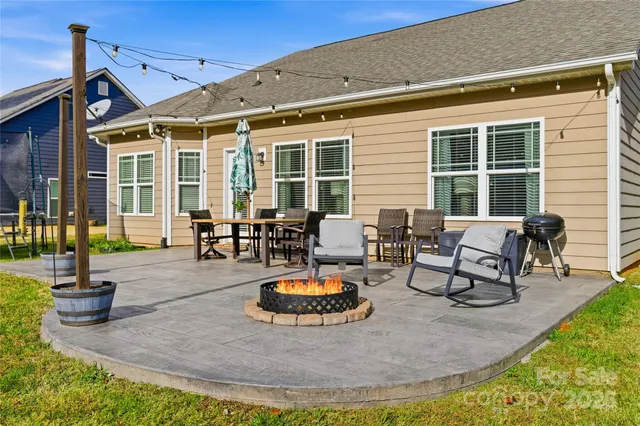 a backyard view of a house with outdoor seating