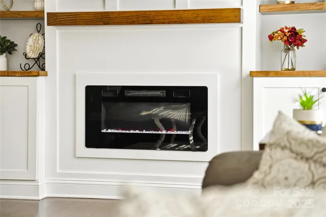 a living room with a fireplace and a potted plant
