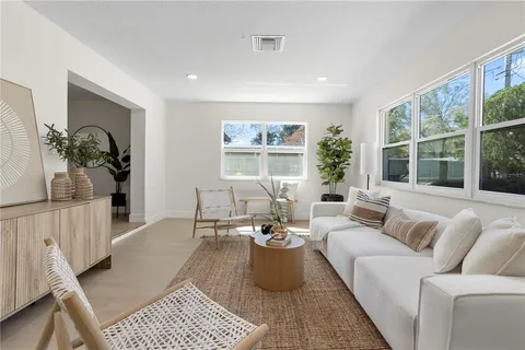 a living room with furniture a window and a wooden floor
