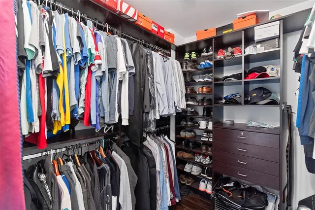 a view of walk in closet with clothes and shoes