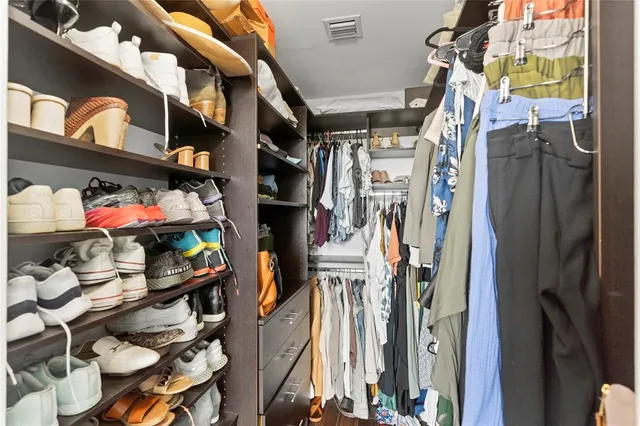 a view of walk in closet with clothes and shoes