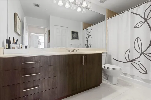 a bathroom with a sink vanity mirror and toilet