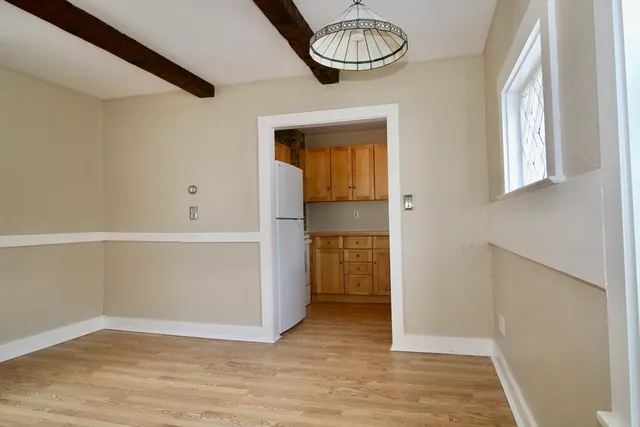 a view of empty room with kitchen and window