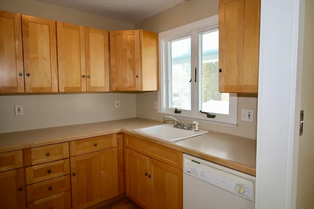 a kitchen with a sink cabinets and window