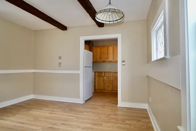 a view of empty room with wooden floor and window