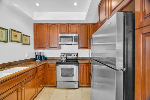 a kitchen with stainless steel appliances granite countertop a sink and a stove top oven