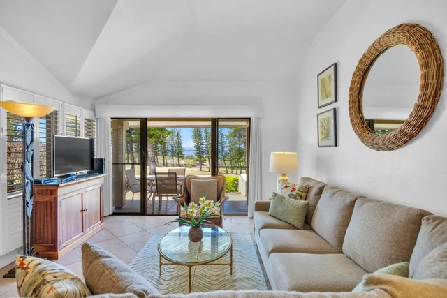 a living room with furniture a flat screen tv and a large window