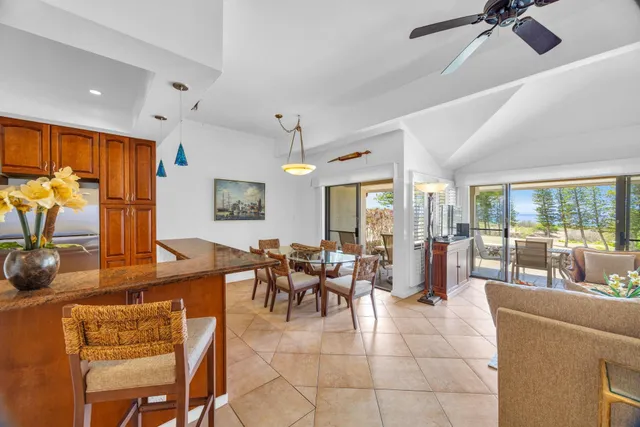 a living room with furniture a chandelier fan and a large window