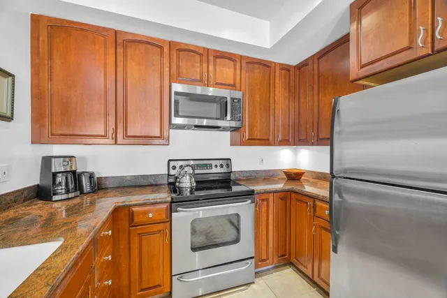 a kitchen with stainless steel appliances granite countertop a refrigerator sink and stove