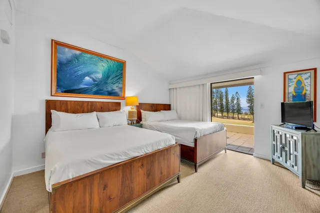 a bedroom with two beds and a flat screen tv