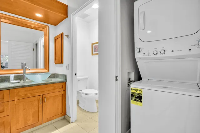 a bathroom with a granite countertop toilet sink and mirror