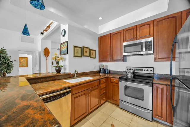 a kitchen with stainless steel appliances granite countertop a stove sink and microwave
