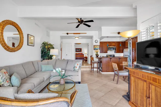 a living room with furniture a flat screen tv and kitchen view