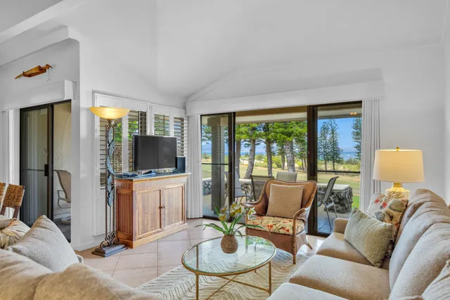 a living room with furniture a large window and a flat screen tv