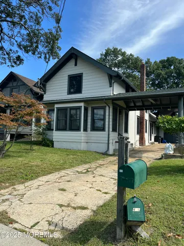 a view of a house with backyard and sitting area