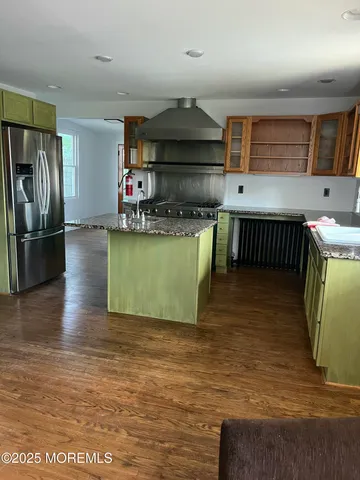 a kitchen with stainless steel appliances granite countertop a sink a stove top oven a counter space and cabinets