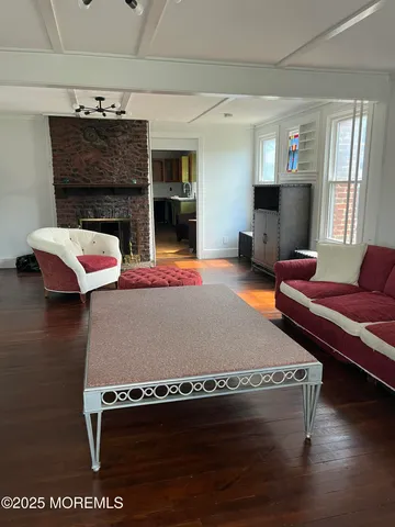a living room with furniture pool table and a fireplace