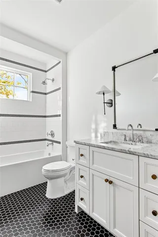 a bathroom with a granite countertop sink a toilet and a mirror