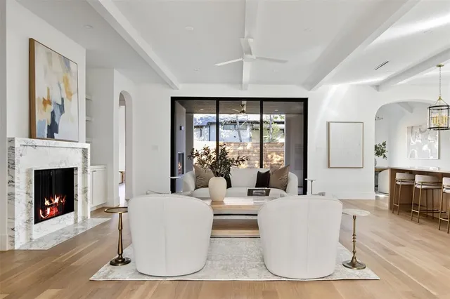 a living room with furniture a fireplace and a large window