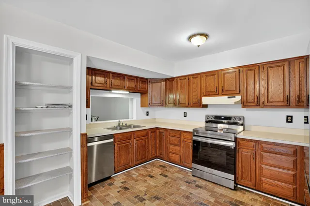a kitchen with a sink stove top oven and cabinets