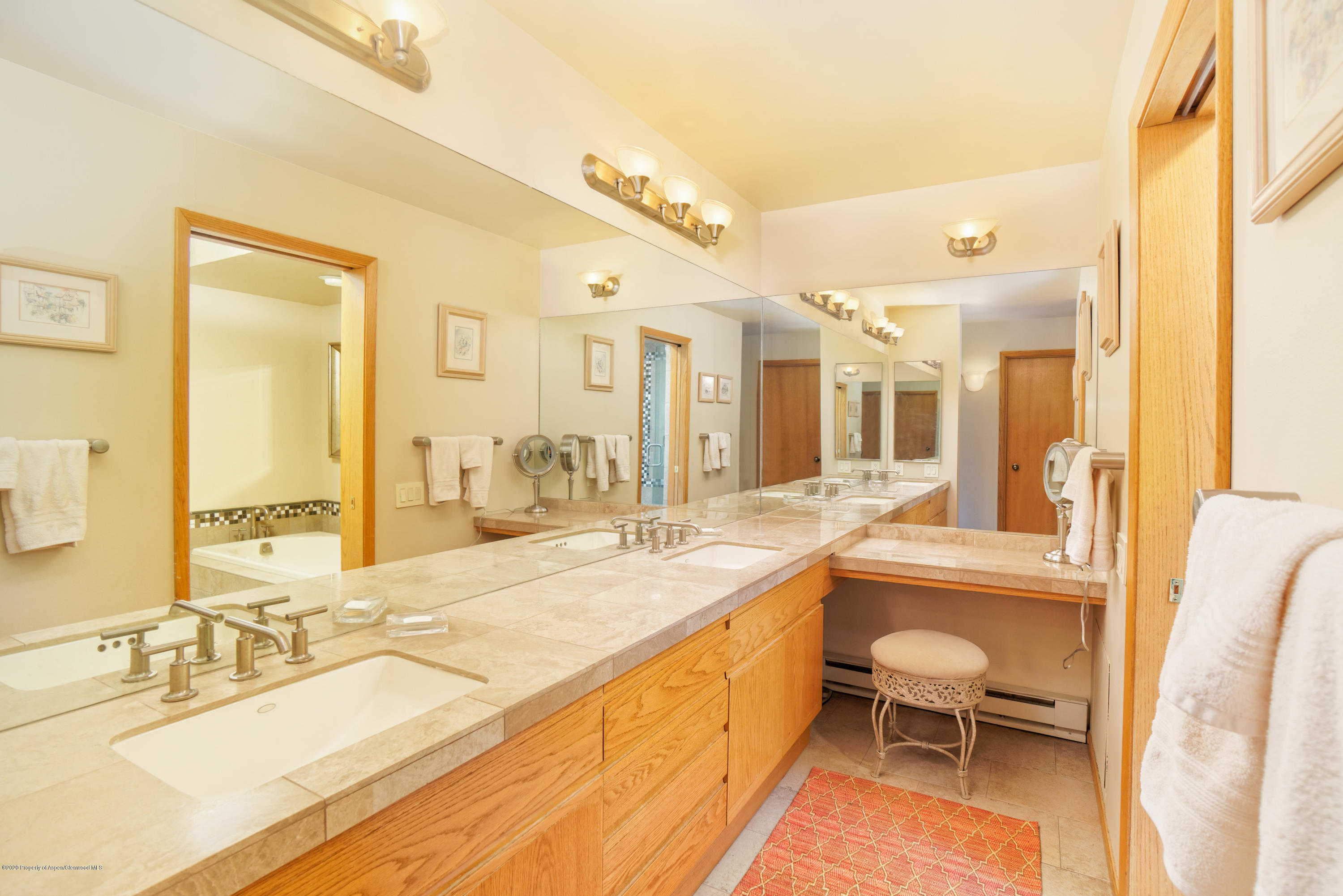 800 Ridge Road, Unit 9 Snowmass Village, CO 81615 - Photo 11 of 42 a large white bathroom with a granite countertop double vanity sink a mirror and a bathtub