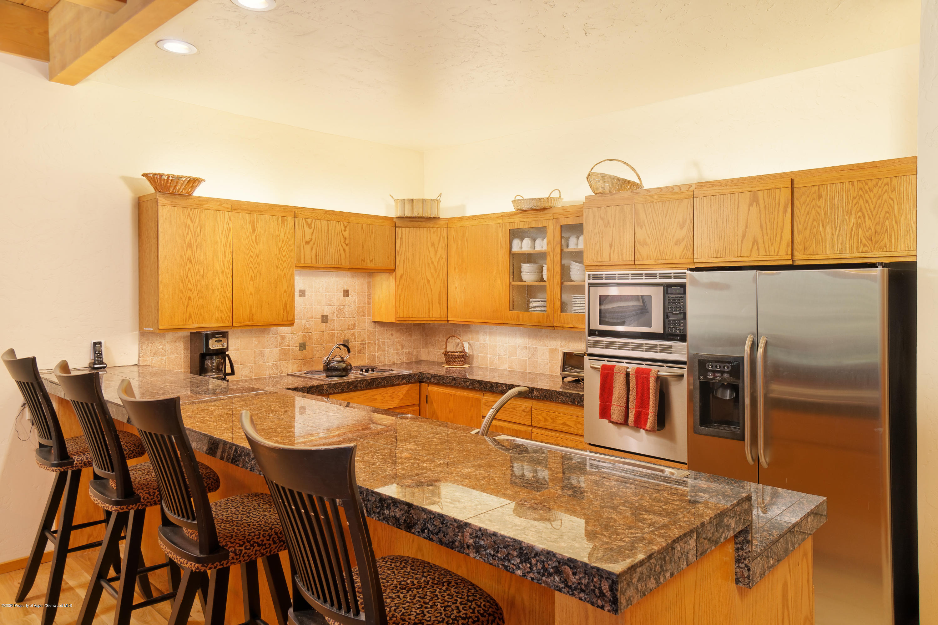 800 Ridge Road, Unit 9 Snowmass Village, CO 81615 - Photo 8 of 42 a kitchen with a table chairs and a refrigerator