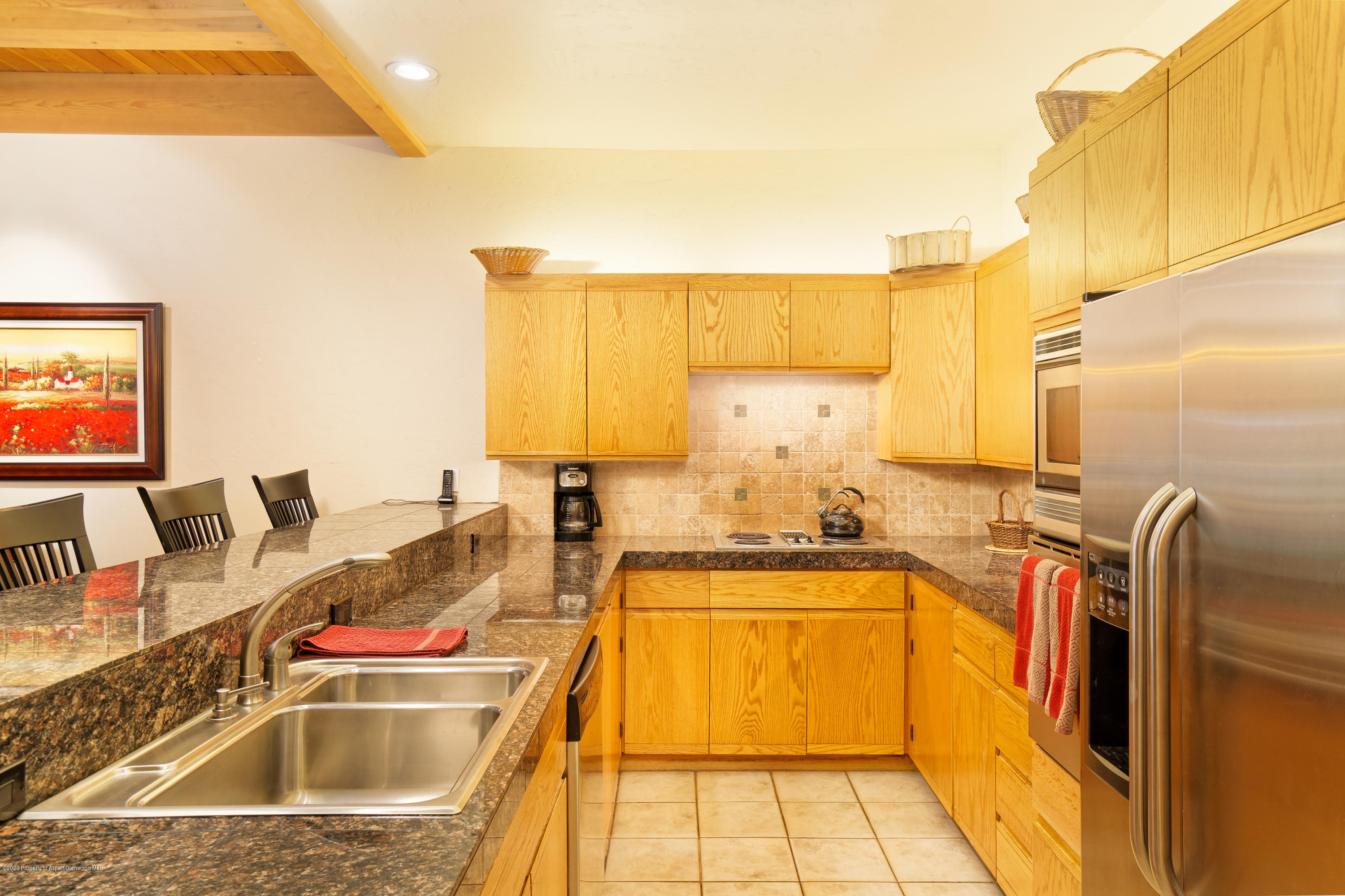 800 Ridge Road, Unit 9 Snowmass Village, CO 81615 - Photo 9 of 42 a kitchen with kitchen island granite countertop a sink stove and cabinets