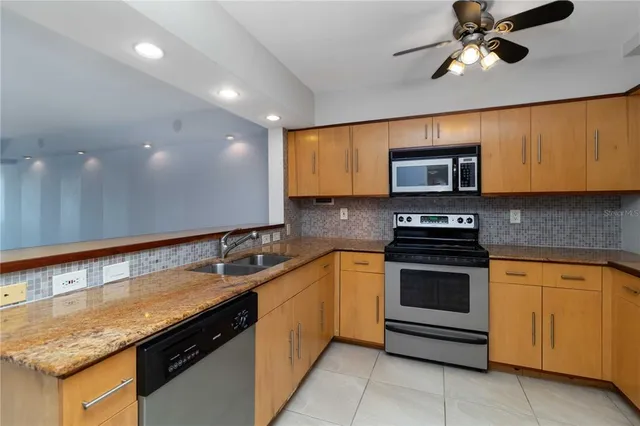 a kitchen with stainless steel appliances granite countertop a sink and a stove