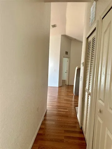 a view of a hallway with wooden floor and staircase