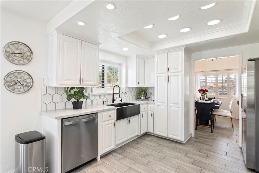 14272 Laurel Drive Riverside, CA 92503 - Photo 2 of 24 a kitchen with white cabinets and refrigerator