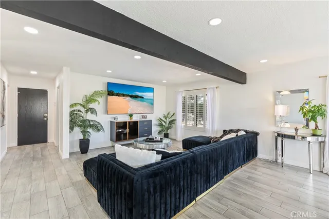 a living room with furniture kitchen view and a large window