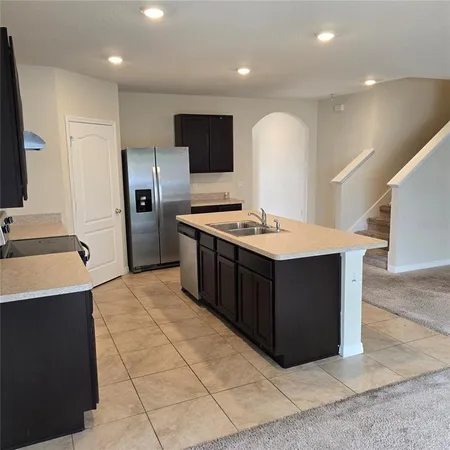 a kitchen with stainless steel appliances granite countertop a sink stove and refrigerator
