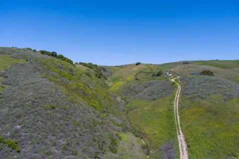 a view of a mountain with a field