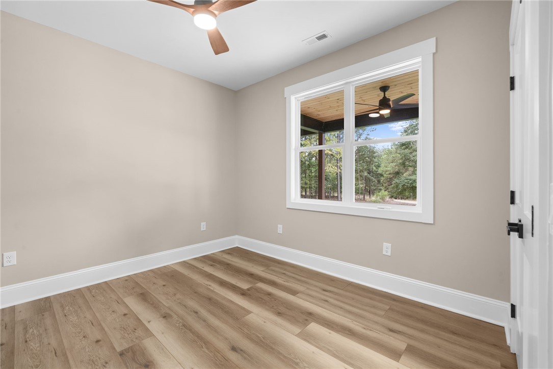 147 McAlister Road West Union, SC 29696 - Photo 22 of 50 Warm wood flooring and a large window frame views of the natural outdoor setting.