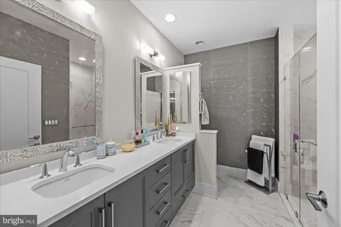 a bathroom with a granite countertop sink mirror vanity and toilet