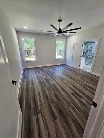 a view of a room with wooden floor and a ceiling fan