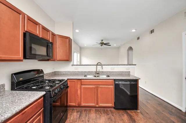 a kitchen with stainless steel appliances granite countertop a sink stove and microwave