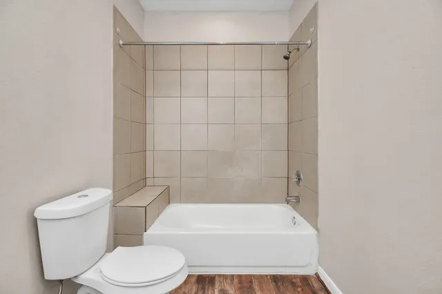 a white toilet and tub sitting next to a white cabinet