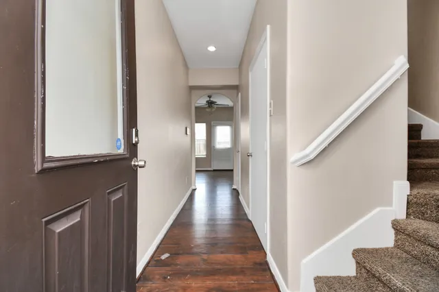 a view of a hallway with wooden floor and staircase