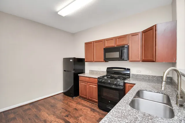 a kitchen with granite countertop a sink stove and microwave