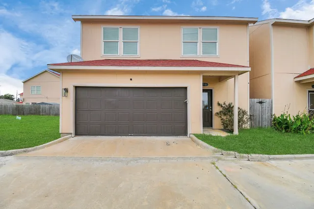 a front view of a house with a yard and garage