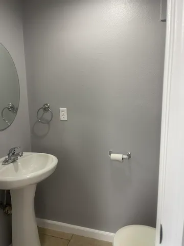 a bathroom with a sink mirror and toilet