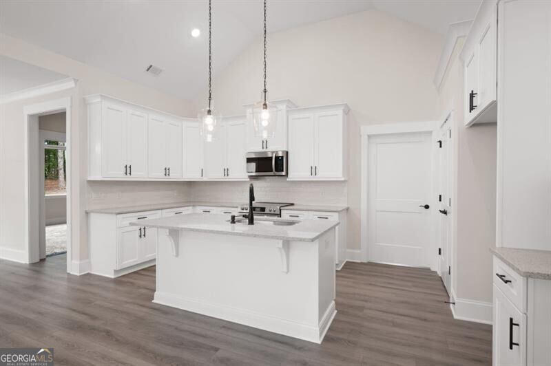 150 Doris Path Dallas, GA 30157 - Photo 14 of 36 a kitchen with kitchen island a sink a stove a refrigerator and white cabinets with wooden floor