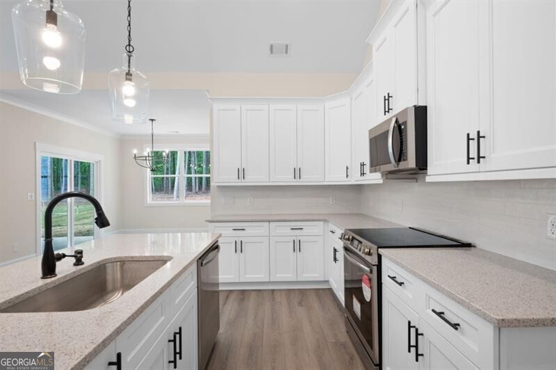 150 Doris Path Dallas, GA 30157 - Photo 15 of 36 a kitchen with granite countertop a sink white cabinets and window