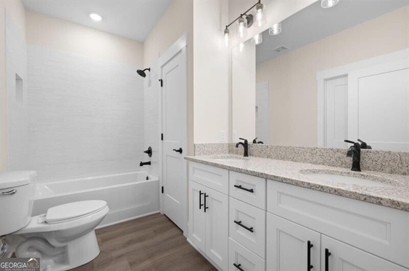 150 Doris Path Dallas, GA 30157 - Photo 25 of 36 a bathroom with a granite countertop sink a toilet and a bathtub